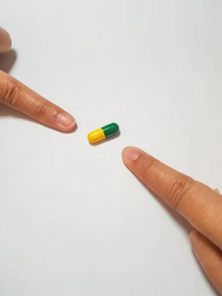 Yeşil Sarı Bir Ilaç Kapsülünü Işaret Eden Iki Işaret Parmağının — Stok fotoğraf