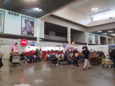 9 Temmuz 2023 'te Bangkok, Tayland. Bangkok Don Mueang Uluslararası Havalimanı 'nın 1 numaralı terminalinin bekleme salonunda birkaç kişi oturuyor. Havanın önünde Asya tezgahının önünde.