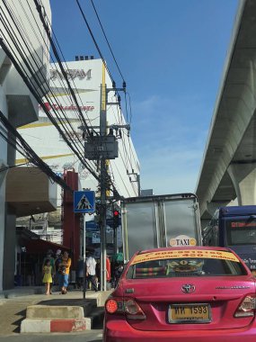 8 Temmuz 2023 'te Bangkok, Tayland. ICONSIAM ve SIAM Takashimaya logoları elektrik direkleriyle kaplı ve Charoen Rat Rd 'de çok dağınık kablolar var. Yanında da BTS parmaklığı var. ICONSIAM Bangkok 'ta çok popüler bir alışveriş merkezidir..