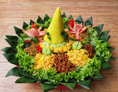 Nasi Tumpeng çok güzel dekore edilmiş sarı pirinç ve çeşitli mezeler içerir, yani orek tempeh, kızarmış tavuk, omlet, doğranmış et ve çeşitli sebzeler..