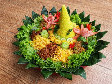 Nasi Tumpeng çok güzel dekore edilmiş sarı pirinç ve çeşitli mezeler içerir, yani orek tempeh, kızarmış tavuk, omlet, doğranmış et ve çeşitli sebzeler..