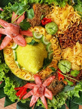 Nasi Tumpeng çok güzel dekore edilmiş sarı pirinç ve çeşitli mezeler içerir, yani orek tempeh, kızarmış tavuk, omlet, doğranmış et ve çeşitli sebzeler..