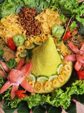 Nasi Tumpeng çok güzel dekore edilmiş sarı pirinç ve çeşitli mezeler içerir, yani orek tempeh, kızarmış tavuk, omlet, doğranmış et ve çeşitli sebzeler..