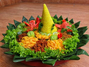 Nasi Tumpeng çok güzel dekore edilmiş sarı pirinç ve çeşitli mezeler içerir, yani orek tempeh, kızarmış tavuk, omlet, doğranmış et ve çeşitli sebzeler..