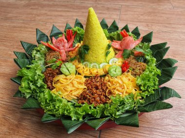 Nasi Tumpeng çok güzel dekore edilmiş sarı pirinç ve çeşitli mezeler içerir, yani orek tempeh, kızarmış tavuk, omlet, doğranmış et ve çeşitli sebzeler..
