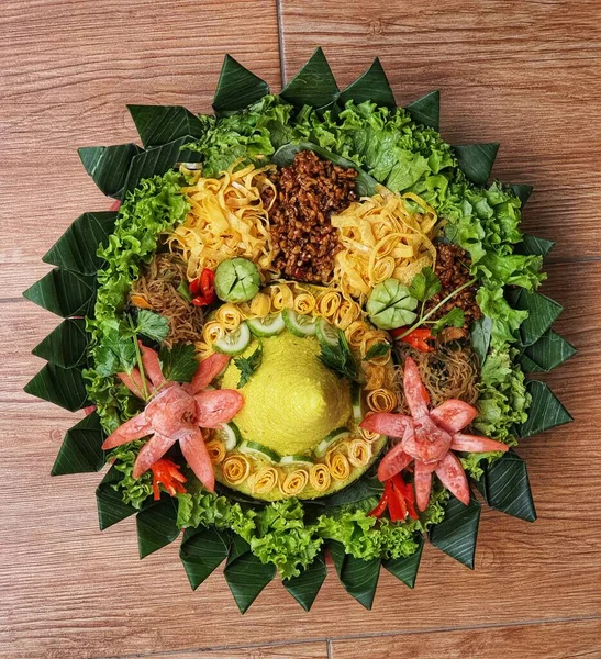 Nasi Tumpeng çok güzel dekore edilmiş sarı pirinç ve çeşitli mezeler içerir, yani orek tempeh, kızarmış tavuk, omlet, doğranmış et ve çeşitli sebzeler..