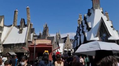 Osaka, Japonya 30 Eylül 2023. Harry Potter 'ın Büyücü Dünyası' nın bir parçası olan Hogsmeade 'e girip çıkan ziyaretçiler. Bir sürü hediyelik eşya ve tereyağı dükkanı var..