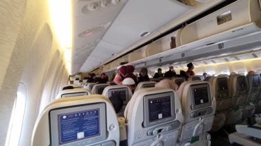 Medine, Suudi Arabistan, 3 Mart 2024. Umrah yolcuları memleketleri Endonezya 'ya dönmek üzere Suudi Arabistan Havayolları uçağına biniyorlar. Uçaktan Jakarta 'ya. Yolcular koltuklarını arasın..