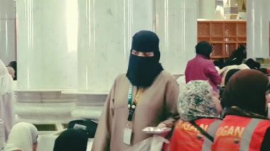 Medine, Suudi Arabistan, 2 Mart 2024. Nabawi Camii 'ndeki kadın namaz alanındaki cemaatler, Müslüman cemaat namaz saatini bekliyor, cemaatin çöplerini toplamak için temizlikçiler etrafta dolanıyor..