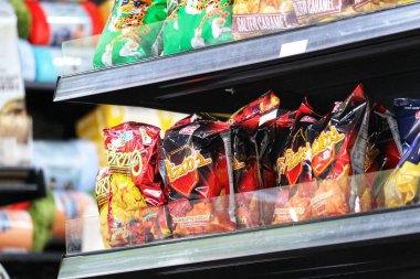 Manila, Filipinler, 29 Eylül 2023. Birkaç paket Piattos Flaming Hot ve Doritos aperatifi havaalanındaki bir mağazanın rafında. Aktiviteler için lezzetli bir atıştırmalık..