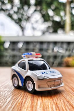 Bir çocuğun oyuncak polis arabasının fotografını çek. Beyaz, sireni var..