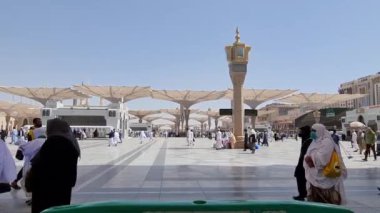 Medine, Suudi Arabistan, 2 Mart 2024. Nabawi Camii 'nin avlusunda yürüyen bir umrah veya hacının bakış açısı. Yürüyen ve ibadet eden cemaati saran görkemli ve güzel şemsiyeleri görebilirsiniz..