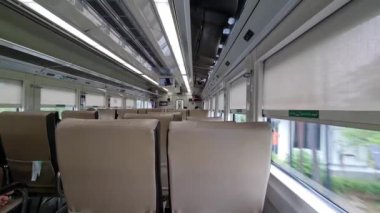 Subang, Endonezya 3 Mart 2024. Ekonomi sınıfı Kuzey Kutojaya Yolcu Treni. Kahverengi banklar, geniş yan pencereler, böylece manzarayı görebilirsin. Tren Kutoarjo 'ya gidiyor..