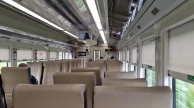 Subang, Endonezya 3 Mart 2024. Ekonomi sınıfı Kuzey Kutojaya Yolcu Treni. Kahverengi banklar, geniş yan pencereler, böylece manzarayı görebilirsin. Tren Kutoarjo 'ya gidiyor..