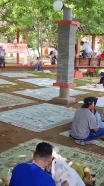 Jepara, 28 Nisan 2024. Bandengan veya Tirta Samudra sahillerini ziyaret edenler sahilde tatilin tadını çıkarıyorlar, bazıları yüzüyor, şamandıralarla oynuyor ve sahilde başka aktiviteler yapıyorlar..