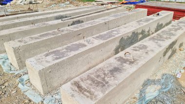 Metal kaldırma döngüleri olan dikdörtgen beton kirişler endüstriyel ve inşaat malzemelerini sergilemek için mükemmel bir inşaat sahasında hazırlanıyor..