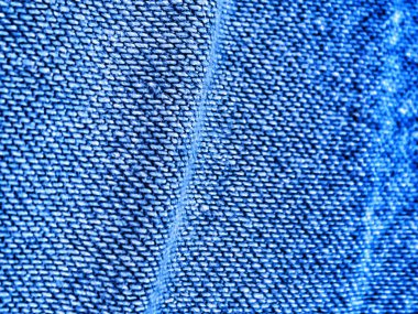 Ayrıntılı yakın plan, görünür dikişli klasik mavi kot kumaşı gösteriyor. Moda veya tekstil arka plan ve tasarımlar için harika..