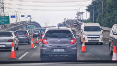 Bekasi, Endonezya 6 Nisan 2025. Yoğun otoyol, otomobiller ve turuncu trafik konileri görülebilir, yoğun bir sahne yaratıyor. Bu görüntüyü ulaşım veya altyapı ile ilgili amaçlar için kullanın..