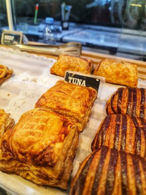 Bekasi, Endonezya 21 Nisan 2025. Ton balığı ve diğer lezzet seçeneklerini sunan bir fırında sergilenen çeşitli altın kahverengi hamur işlerinin kapanışı yemek ve yemek konseptleri için idealdir..