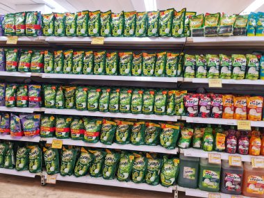 Bekasi, Endonezya 21 Nisan 2025. İyi stoklanmış bir süpermarket koridorunda ev alışverişi ihtiyaçlarını karşılamak için sıra sıra temizlik malzemeleri ve konteynırlar dizili raflar..