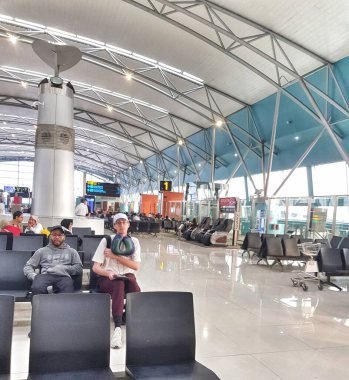 Cengkareng, Endonezya 6 Kasım 2024. Modern bir havaalanının kalkış salonu huzurlu bir atmosfer sunar. Yolcular gösterişli koltuklarda rahatlar, yüksek tavan ve doğal ışık yolculuklarından önce sakin bir alan yaratır..