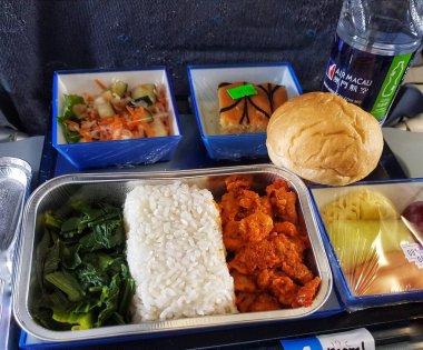 Taipa, Macau 6 Kasım 2024 'te. Air Macau 'da. Müslüman Yemeği. Helal. Tuzlu tavuk, kabarık pirinç ve canlı yeşiller uçuşta lezzetli bir yemek oluşturur. Tatlı bir pasta ve taze salata bu iştah açıcı tepsiyi tamamlar..