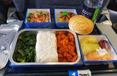 Taipa, Macau 6 Kasım 2024 'te. Air Macau 'da. Müslüman Yemeği. Helal. Pirinç, baharatlı tavuk, yeşillik ve taze meyvenin yer aldığı lezzetli görünümlü bir uçuş yemeği. Basit ama tatmin edici bir tepsi, hava yolculuğu için mükemmel..