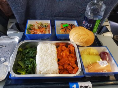 Taipa, Macau 6 Kasım 2024 'te. Air Macau 'da. Müslüman Yemeği. Helal. Lezzetli bir uçuş yemeği bekliyor! Baharatlı tavuk, kabarık pirinç, canlı yeşillikler ve tatlı bir ziyafet 30 bin fitte doyurucu ve dengeli bir Asya yemeği deneyimi yaratıyor..