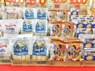 Seul, Güney Kore, 12 Kasım 2024. Canlı bir piyasa sahnesinde sütlü pirinç atıştırmalıkları ve tereyağlı kurabiyeler sergilenerek sıcak ve davetkar bir atmosfer yaratılıyor. Paket parlak ve göz alıcı..