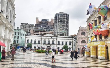Largo do Senado, Macau 14 Kasım 2024. Yağmurlu bir günde Macau 'daki Senado Meydanı' nda Portekiz mimarisi ve şen şakrak şişme süslemeleri sergileniyor. Büyüleyici, biraz melankolik bir atmosfer..