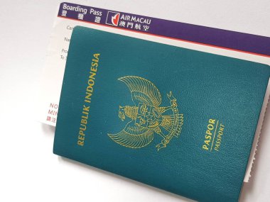 Macau, Çin 14 Kasım 2024. Bir Endonezya pasaportu Air Macau uçuş kartının üzerinde, yaklaşan bir yolculuğu ima ediyor. Deniz mavisi pasaportunun altın amblemi biraz zarafet katıyor..