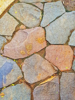 Değişik renklere ve dokulara sahip taştan bir yolun yakın plan veya tasarım projeleri için mükemmel.