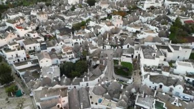 Alberobello 'nun hava manzarası, eşsiz bir manzarası olan bir kasaba. Trulli 'nin beyaz çatıları İtalyan topraklarına gömülüdür. İnsansız hava aracından Alberobello 'nun bu eşsiz manzarasının tüm güzelliklerini görebilirsiniz..