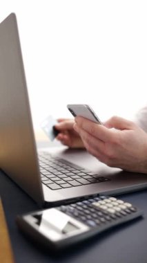  İnternet üzerinden alışveriş yaparken, bir kişi akıllı telefon ve banka kartı kullanır. Modern dijital ticaret platformlarının kolaylığı ve erişilebilirliği. Çevrimiçi mağazalarda çevrimiçi ödeme güvenliği kavramı.