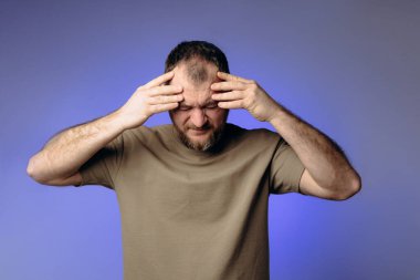 Bir adamın şiddetli bir baş ağrısı vardır. Kafasındaki ağrıyı hafifletmek için kafasını ellerinin arasına alıp şakaklarına masaj yapıyor. Atmosfer basıncındaki değişiklikler fiziksel durumu ve baş ağrısını etkiler..