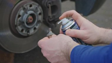  Bir lastik tesisatçısı tekerlek takmadan önce cıvataları ve delikleri yağlar. Yağ metal aşınmasını önler ve cıvataları gevşetir veya sıkılaştırır..