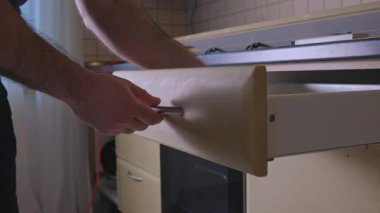 Adam mutfak tadilatı yapıyor. Marangoz tadilattan önce mutfağı parçalara ayırıyor. Usta bir zanaatkar mutfağı modernleştirmek için el aletleri kullanır. İşlemler devam ediyor. Yüksek kalite 4k görüntü