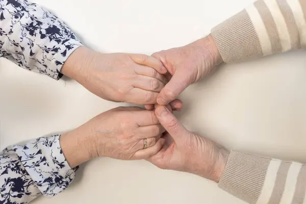 Erkek elleri, cildinde yaşla ilgili değişikliklerle güçlü bağları, özeni ve desteği sembolize eder. Bu çekim, aile ilişkilerinin sıcaklığını ve yıllardır biriken güveni aktarıyor. Yüksek