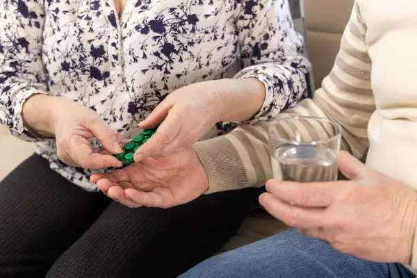 Kocasına ilaç veren bir eş. Sağlıklı yaşlı çiftler birbirlerine iyi bakarlar. - Evet. Yüksek kalite fotoğraf