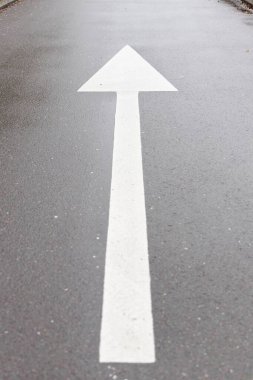 Beyaz ok sembolü asfalt bir caddede düz bir istikamette, ulaşım konseptinde. Yüksek kalite fotoğraf