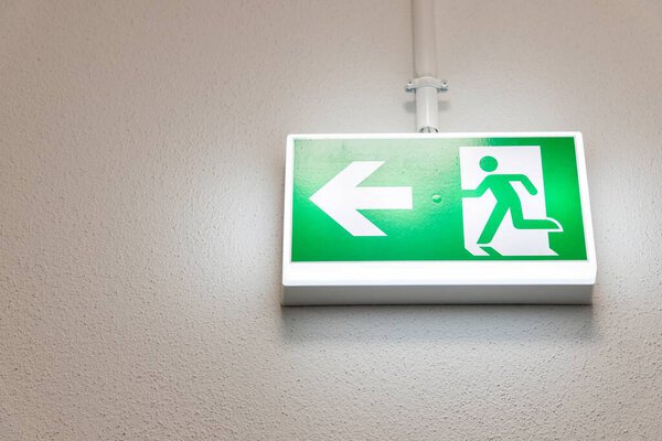Fire Emergency exit sign on the wall background inside building. Safety concept. High quality photo