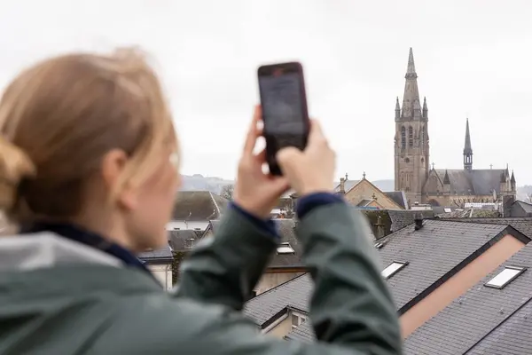 Genç bir kadın cep telefonundaki işaretlerin fotoğraflarını çekiyor. Odak noktasında bir işaret. Yüksek kalite fotoğraf