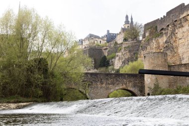 Bulutlu Lüksemburg şehri manzarası, kilise kulesi, kemerli köprüler ve nehir kenarında yürüyüş. Yüksek kalite fotoğraf