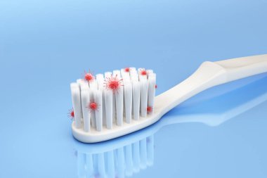 White toothbrush. Microscopic view Uncleaned toothbrush bristles contain bacteria, fungi, virus, red stains on blue background. Resulting in tooth decay, swollen gums and bad breath. 3D Illustration.