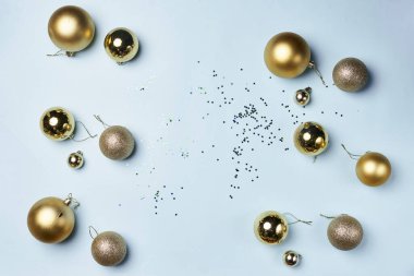 Bazı altın noel topları ve konfeksiyon beyaz bir yüzey üzerinde dağınık şekerleme nesneleri arka planda