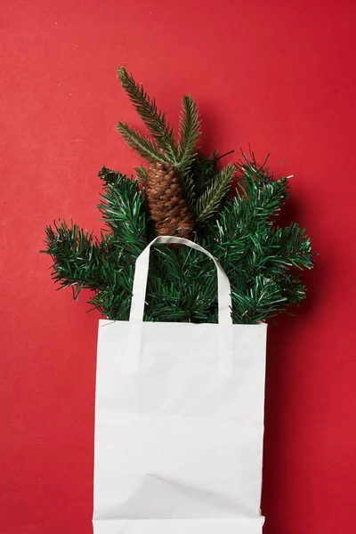 stock image a christmas tree in a white shopping bag on a red background with copy space for your text or image stock photo