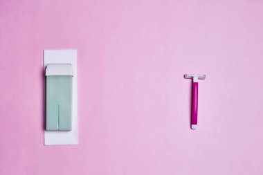 Solunda diş fırçası olan pembe bir duvar ve sağında beyaz bir diş fırçası, soluk pembe bir arka planda.