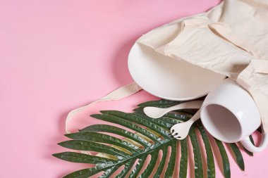 Pembe arkaplandaki bazı beyaz tabaklar ve palmiye yaprakları - sağ üst köşedeki boşluk boş