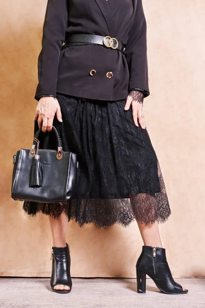 Siyah Elbiseli Bir Kadın Bir Çanta Tutuyor Bej Bir Duvarın — Stok fotoğraf