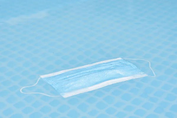 Een Gezichtsmasker Drijvend Een Zwembad Met Waterdruppels Het Oppervlak Ter — Stockfoto